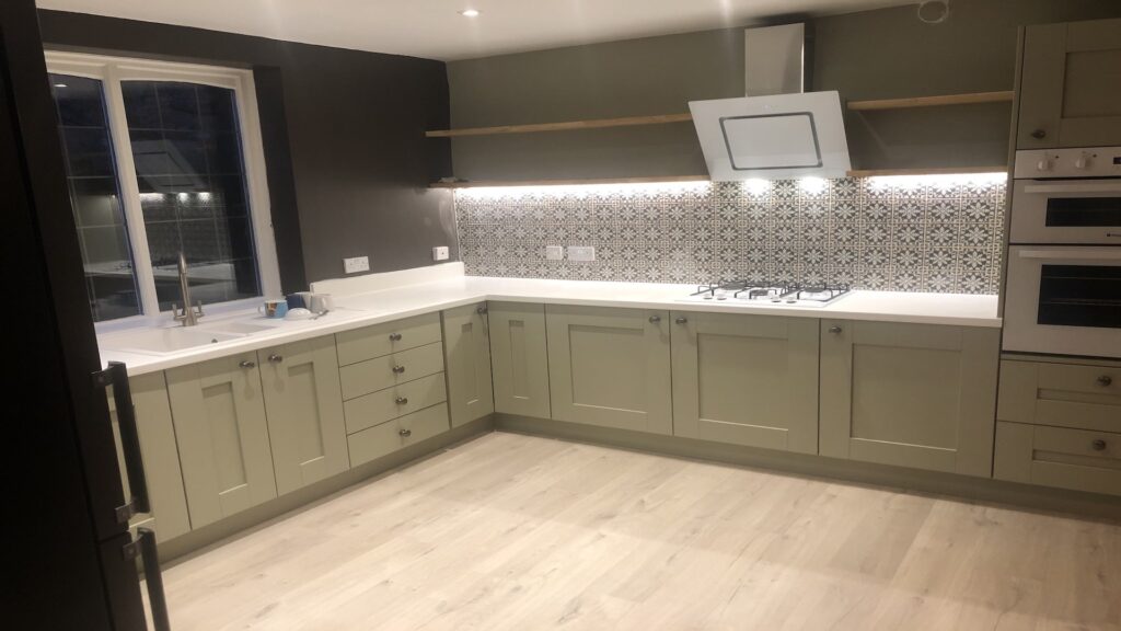 sage green kitchen patterened splashback white worktops